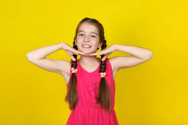 Menina bonita em vestido rosa no fundo amarelo — Fotografia de Stock