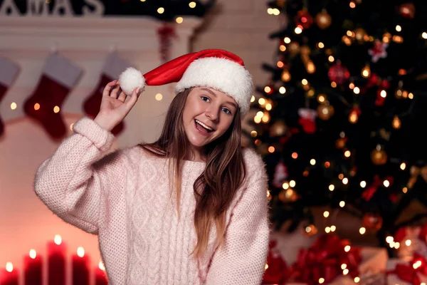 집에서 크리스마스 트리 근처 산타 모자에 소녀 — 스톡 사진