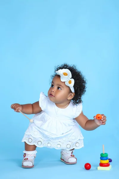 美丽的女婴与塑料玩具的蓝色背景 — 图库照片