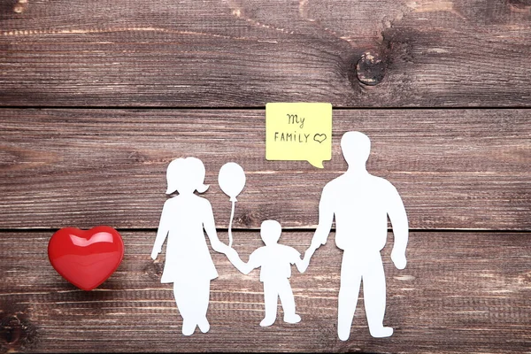 Family figures with red heart and speech bubble on wooden table — Stock Photo, Image