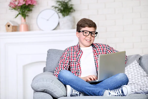 Молодий хлопець з ноутбуком сидить на дивані — стокове фото