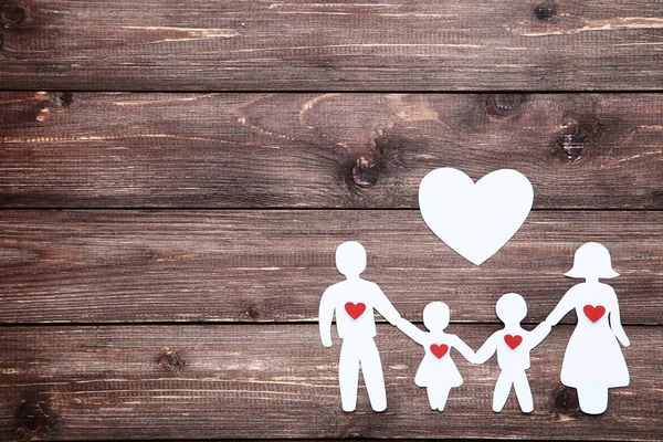 Familienfiguren mit Herzen auf braunem Holztisch — Stockfoto