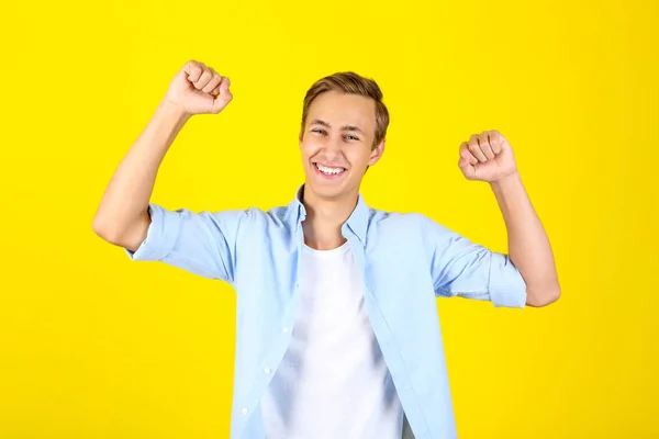 Gelukkig jonge man in shirt op gele achtergrond — Stockfoto
