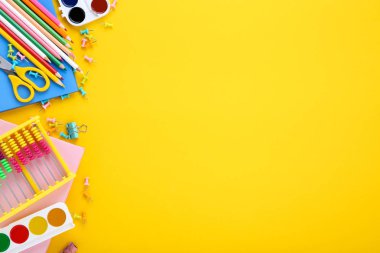 Sarı arka planda farklı okul malzemeleri