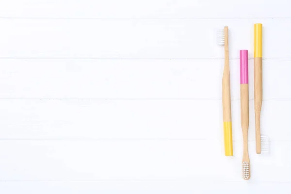 Bamboo toothbrushes on white wooden table — Stock Photo, Image