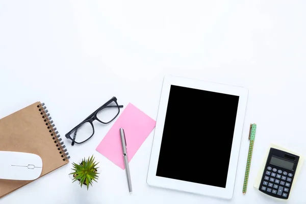 Tablet computer with office supplies on white background — Stock Photo, Image