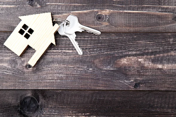 Llaves de plata con símbolo de la casa en la mesa de madera marrón — Foto de Stock