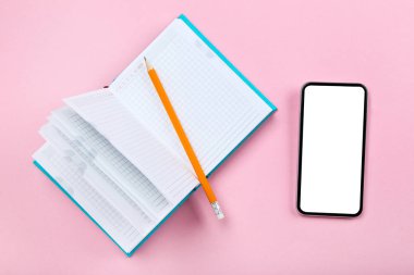 Pembe arka plan üzerinde not defteri ve kalem ile Akıllı telefon