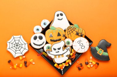 Turuncu arka planda şekerler ile Halloween gingerbread çerezleri