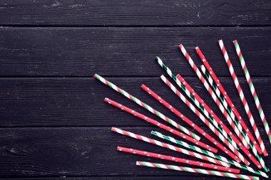 Siyah ahşap masa üzerinde renkli kağıt pipetler