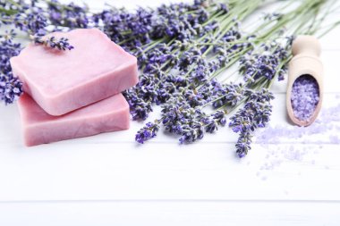 Beyaz ahşap masada spa tuzu ve sabun ile Lavanta çiçekleri