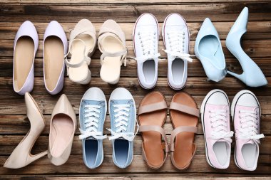 Kahverengi ahşap masa üzerinde farklı kadın ayakkabı