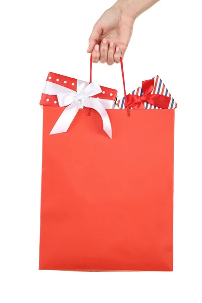 Female hand holding shopping bag with gift boxes on white backgr — Stock Photo, Image