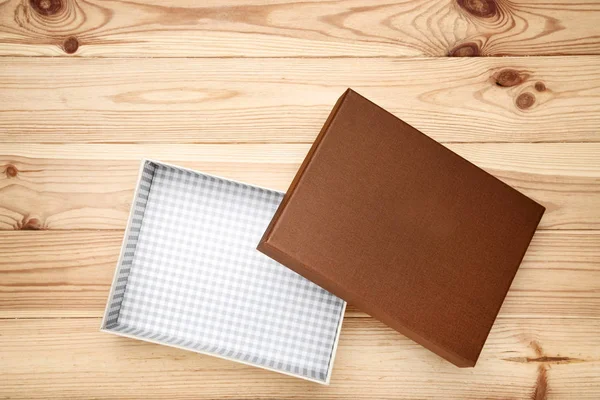 Buka kotak hadiah di meja kayu cokelat — Stok Foto