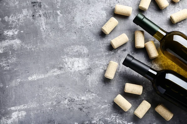 Weinflaschen mit Korken auf grauem Holztisch — Stockfoto