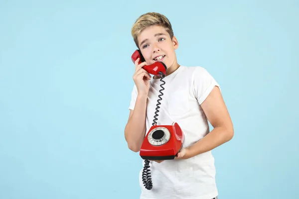 Jeune garçon avec combiné et téléphone sur fond bleu — Photo