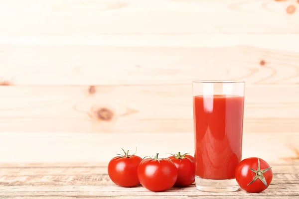 Tomatensaft im Glas auf braunem Holztisch — Stockfoto