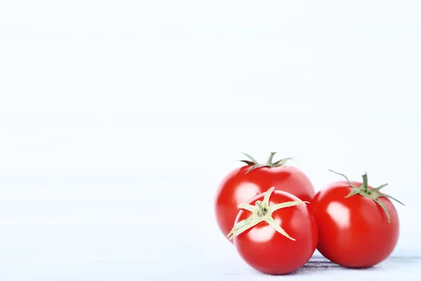 Tomates frescos e maduros sobre mesa de madeira — Fotografia de Stock