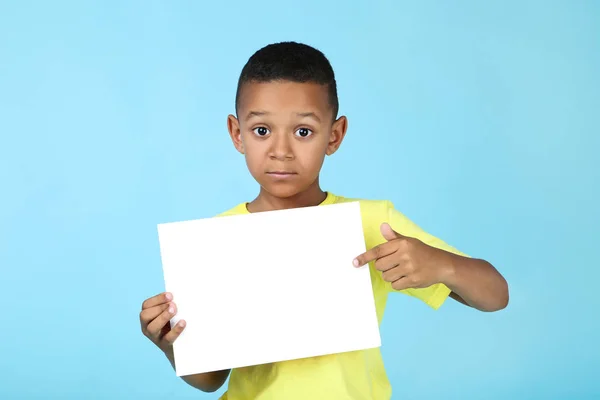 Süßer amerikanischer Junge mit leerem Brett auf blauem Hintergrund — Stockfoto