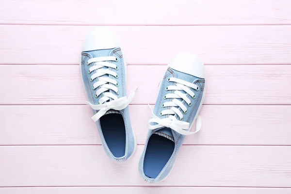 Par de zapatillas azules en mesa de madera rosa —  Fotos de Stock