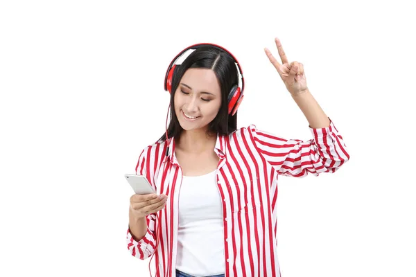 Hermosa mujer con auriculares y teléfono inteligente en backgrou blanco — Foto de Stock
