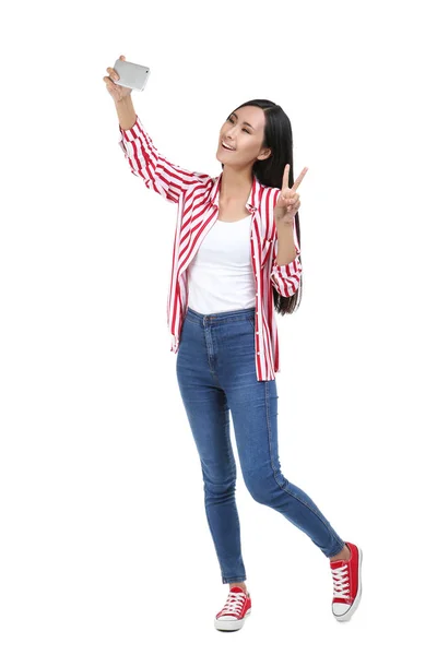 Jonge vrouw maken selfie op smartphone op witte achtergrond — Stockfoto