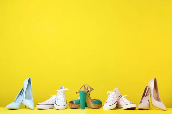Zapatos femeninos diferentes sobre fondo amarillo —  Fotos de Stock