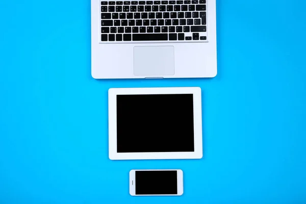 Озил, ноутбук со смартфоном на синем фоне — стоковое фото