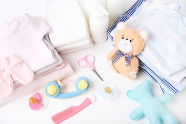 Yumuşak ayı oyuncağı ve bebek malzemeleri ile katlanmış giysiler.