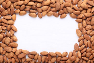 Beyaz ahşap masa üstünde badem