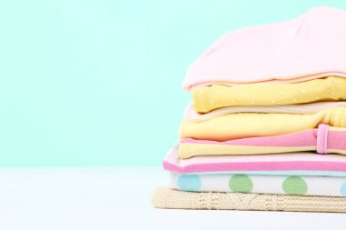 Mavi arka planda farklı katlanmış bebek giysileri