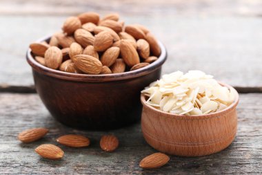 Gri ahşap masa üzerinde kaselerde Badem