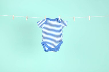 Mavi arka planda asılı bebek kıyafetleri