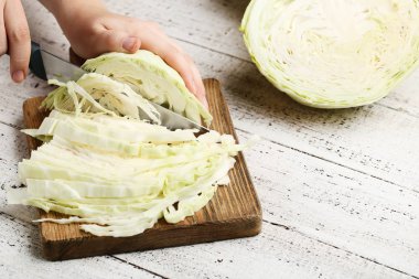 Kadın el kahverengi tahta üzerinde bıçak lahana kesme