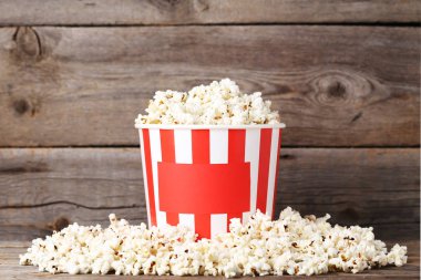 Ahşap masa üzerinde çizgili Kova patlamış mısır