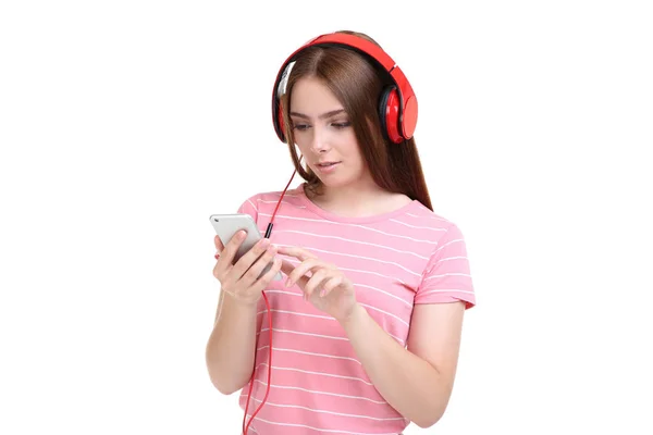 Jonge vrouw met koptelefoon en mobiele telefoon op witte achtergrond — Stockfoto