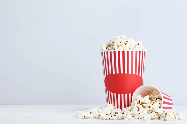 Popcorn in striped buckets on grey background — Stock Photo, Image