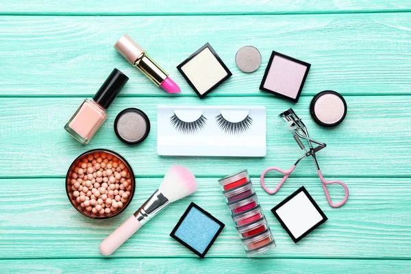 Different makeup cosmetics on mint wooden table — Stock Photo, Image