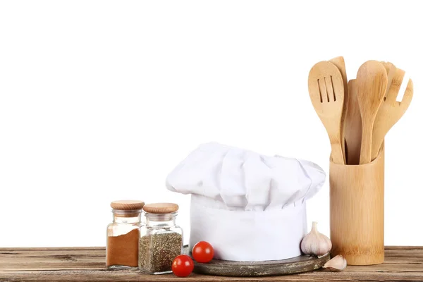 Cappello da chef con spezie in vasetti e verdure su tavoletta di legno marrone — Foto Stock