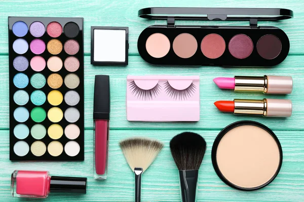 Diferentes cosméticos de maquillaje en la mesa de madera de menta — Foto de Stock