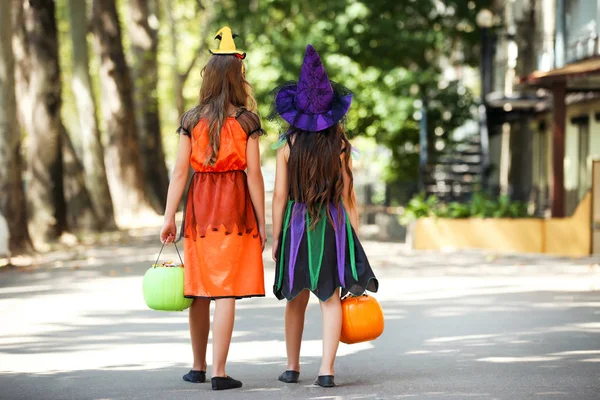 Jonge meisjes in Halloween kostuums met Pumpkin emmers wandelen op — Stockfoto