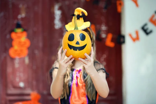 Красивая девушка в костюме Хэллоуина держит тыкву — стоковое фото