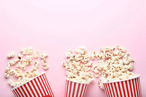 Palomitas de maíz en cubos rayados sobre fondo rosa —  Fotos de Stock