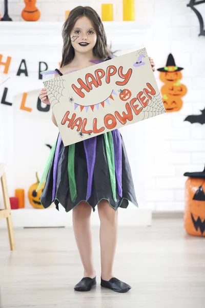 Красивая девушка в костюме держит бумагу с текстом Happy Hallowee — стоковое фото