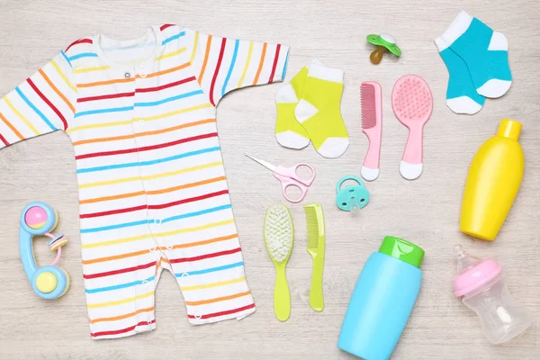 Roupas com suprimentos de bebê no chão — Fotografia de Stock