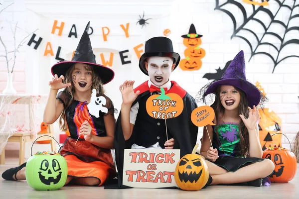 Giovani due ragazze e ragazzo in costumi di Halloween che tengono ghos di carta — Foto Stock