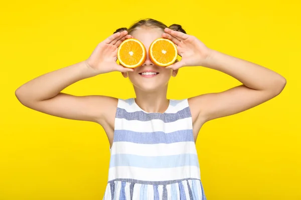 Gadis cantik memegang buah jeruk segar di latar belakang kuning — Stok Foto