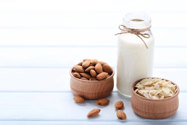 Amande et lait en bouteille sur table en bois — Photo