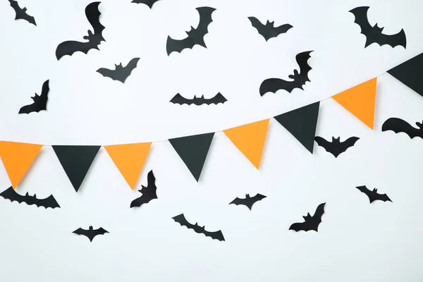 Paper halloween bats and flags on white background