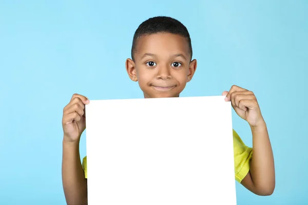 Süßer amerikanischer Junge mit leerem Brett auf blauem Hintergrund — Stockfoto